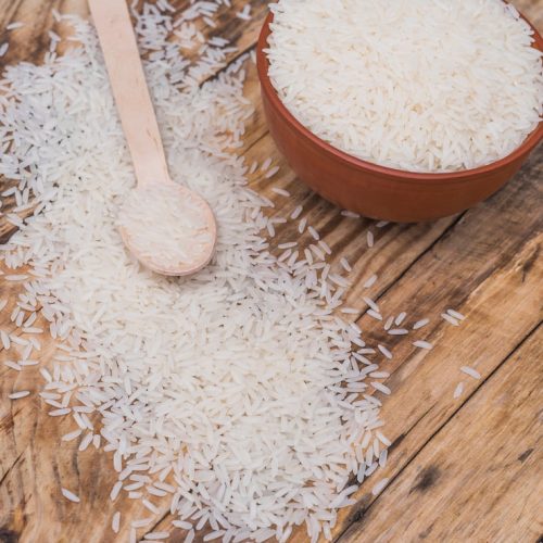 high-angle-view-fresh-raw-rice-bowl-with-small-spoon-textured-wooden-background_23-2148097259